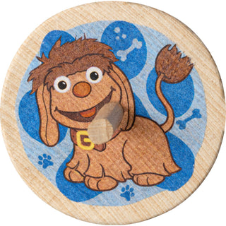 Holzkreisel ‚Moppi‘, 4 cm groß, farbig bedruckt. Auf der runden Scheibe ist die Hundfigur Moppi vor blauem Hintergrund mit Pfoten- und Knochenmotiven abgebildet; der Kreisel hat einen mittigen Holzstab. Frontansicht