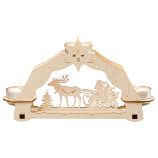 Holz-Kerzenhalter mit filigraner Silhouette eines Rentiers, eines Tannenbaums, eines Weihnachtsmanns im Schlitten und drei platzierten Teelichthaltern unter einem Bogen mit Sternenhimmel.
