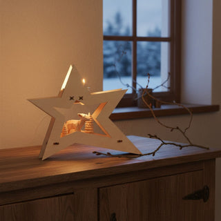 Kerzenhalter für 1 Teelicht „Reh“, 15 cm, aus naturbelassenem Holz in moderner Sternform mit filigraner Reh‑Szene im Inneren, dekorativ auf einem Holzsideboard neben Zweigen platziert, vor einem Fenster mit winterlicher Landschaft und warm leuchtendem Kerzenlicht.