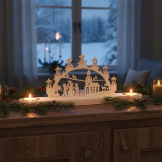 Kerzenhalter Mini für 2 Teelichte „Schwibbogen Schneemann“, 32 cm, aus naturbelassenem Holz mit filigraner Schwibbogen‑Szene mit Schneemann, Figuren und Kirche, dekorativ auf einem Sideboard mit Tannenzweigen und roten Beeren arrangiert, vor einem Fenster mit verschneiter Winterlandschaft und warm leuchtenden Teelichtern.