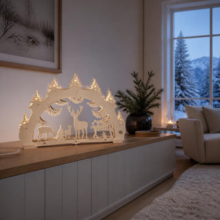 LED-Schwibbogen „Waldlichtung“, 52 cm, mit detailreich gestalteter Waldlandschaft aus naturbelassenem Holz. Im Mittelpunkt stehen ein prächtiger Hirsch, Rehe sowie filigrane Tannenbäume auf mehreren Ebenen. Die integrierte warmweiße LED-Beleuchtung hebt die feinen Konturen der Waldszene hervor und schafft eine gemütliche, festliche Atmosphäre im traditionellen Erzgebirgsstil.