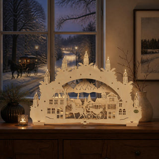 LED Schwibbogen „Pferdekutsche“ natur, 52 cm, mit detailreicher Dorfszene aus hellem Holz. Das beleuchtete Motiv zeigt ein Pferdegespann mit Kutsche vor Fachwerkhäusern, einer Kirche und einer Berglandschaft. Die warmweiße LED-Beleuchtung sorgt für eine festliche Atmosphäre und setzt die filigranen Details der mehrlagigen Holzarbeit stimmungsvoll in Szene. Dekorativ platziert auf einer Fensterbank als traditionelle Weihnachtsdekoration.