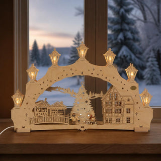 LED-Schwibbogen „Weihnachtsbaum am Markt“, 52 cm, mit detailreicher Marktszene aus hellem Holz. Im Mittelpunkt steht ein festlich geschmückter Weihnachtsbaum, ergänzt durch einen Marktstand, ein filigran gearbeitetes Fachwerkhaus und liebevolle Dekofiguren. Die beleuchteten Laternen auf dem Schwibbogen und die warmweißen LEDs schaffen eine gemütliche, traditionelle Weihnachtsstimmung im Erzgebirgsstil.