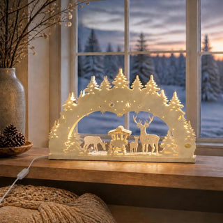 LED-Schwibbogen „Wald“, 52 cm, mit detailreich gelaserter Waldszene aus Tannenbäumen, Hirschfamilie und Futterkrippe. Die warmweiße LED-Beleuchtung hebt die filigranen Motive hervor und schafft eine gemütliche, festliche Stimmung. Ideal als weihnachtliche Fensterdekoration im klassischen Erzgebirgsstil.