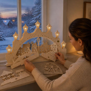 LED-Schwibbogen „Winterfreuden in der Stadt“ mit Wechselmotiv, 52 cm, aus naturbelassenem Holz. Der dekorative Schwibbogen zeigt eine winterliche Stadtkulisse mit beleuchteten Laternen und wird durch austauschbare Motivplatten individuell gestaltet. Die verschiedenen Einleger mit Winter- und Weihnachtsmotiven ermöglichen abwechslungsreiche Dekorationen, während die warmweiße LED-Beleuchtung für eine gemütliche und festliche Atmosphäre sorgt.