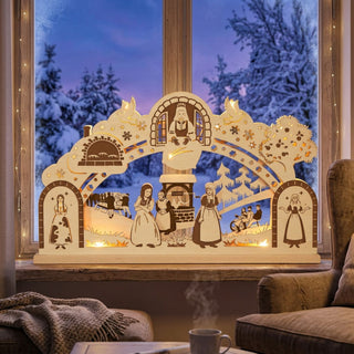 LED-Schwibbogen „DEFA-Frau Holle“ aus hellem Holz mit 10 warmweiß leuchtenden LEDs. Die detailreiche, farbig abgesetzte Szenerie zeigt Motive aus dem Märchen „Frau Holle“, darunter die Figur am Fenster, den Brunnen, den Backofen sowie verschiedene Szenen mit Figuren in einer Winterlandschaft. Dekorative Schneeflocken, Vögel und Bäume schmücken den Schwibbogen. Der 52 cm breite Leuchtbogen steht auf einer Fensterbank vor verschneiter Winterkulisse und sorgt für eine stimmungsvolle Weihnachtsatmosphäre.