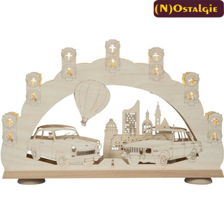 Der 7-flammige Schwibbogen mit 3D Effekt hat ein besonders schönes, an frühere (DDR-) Zeiten erinnerndes Motiv. Die Fahrzeuge Trabant und Wartburg - in den dargestellten Modellen - begleiteten die Menschen im Osten Deutschlands über viele Jahrzehnte und wecken Erinnerungen an Erlebtes in vergangenen Tagen. Im Hintergrund steigt über die Stadt Leipzig ein Heißluftballon auf. 7 Lichtsignalanlagen mit Ampelmännchen umranden den Bogen. Bild 1.