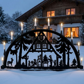 Metallschwibbogen für den Außenbereich „Waldhaus“ in Schwarz mit detailreicher Waldszene. Der 100 cm breite Schwibbogen zeigt ein Waldhaus zwischen hohen Tannen, Figuren bei weihnachtlichen Tätigkeiten sowie einen Rehbock am Waldrand. Zehn warm leuchtende Kerzen setzen die filigranen Silhouetten stimmungsvoll in Szene und sorgen für eine festliche Atmosphäre im Außenbereich.