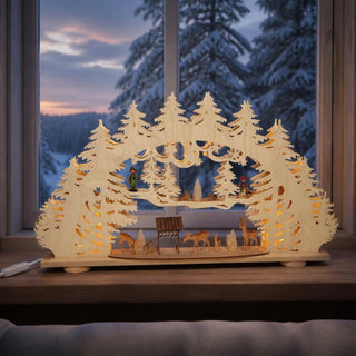 Schwibbogen „Waldlichtung mit geschnitzten Figuren“, 69 cm, mit kunstvoll gearbeiteter Waldlandschaft aus mehreren Ebenen. Zwischen filigranen Tannenbäumen sind Rehe, eine Futterkrippe sowie liebevoll gestaltete geschnitzte Figuren arrangiert. Die integrierte warmweiße Beleuchtung sorgt für eine gemütliche Weihnachtsatmosphäre und unterstreicht den traditionellen Erzgebirgscharakter der Dekoration.