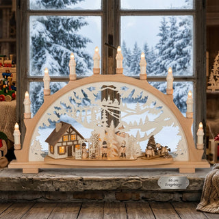 LED Schwibbogen „Winterkinder“ aus naturfarbenem Holz mit liebevoll gestalteter Winterszene. Der 66 cm breite Lichterbogen zeigt ein beleuchtetes Fachwerkhaus, spielende Kinder, einen Schneemann und verschneite Tannen vor einer filigranen Winterlandschaft. Mehrere Kerzenlichter und warmweiße LEDs sorgen für eine stimmungsvolle Weihnachtsatmosphäre.