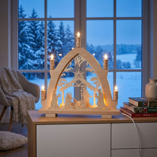 LED Lichterspitze „Christi Geburt“ aus naturfarbenem Holz mit filigraner Krippenszene. Die 43 cm hohe Weihnachtsdekoration zeigt Maria, Josef und das Christkind unter dem Stern von Bethlehem, eingerahmt von fünf leuchtenden Kerzen. Warmweißes Licht sorgt für eine besinnliche und festliche Weihnachtsatmosphäre.