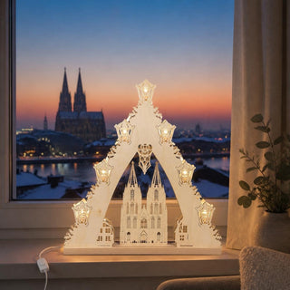 LED-Lichterspitze „Kölner Dom“ aus naturfarbenem Holz mit filigraner Darstellung des Kölner Doms. Die 7-flammige LED-Beleuchtung sorgt für warmes, stimmungsvolles Licht und hebt die detailreichen Holzschnitte hervor. Die 42 cm hohe Lichterspitze ist eine festliche Weihnachtsdekoration für Fensterbank, Sideboard oder Wohnbereich.