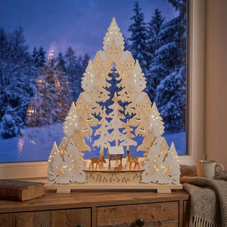 LED Lichterspitze „Waldzauber“ aus naturfarbenem Holz mit filigraner Waldszene, geschnitzten Rehen und dekorativem Raureifeffekt. Die 65 cm hohe Weihnachtsdekoration zeigt verschneite Tannen, kleine Waldhäuser und einen Futterplatz inmitten des Waldes. Warmweiße LEDs sorgen für eine stimmungsvolle Beleuchtung und unterstreichen die winterliche Atmosphäre.