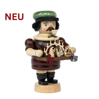 Farbiges Räuchermännchen „Schwibbogenhändler“ aus Holz, mit grünem Hut und Bauchladen, auf dem kleine Schwibbogen‑ und Figuren­motive präsentiert werden; 20 cm hoch.