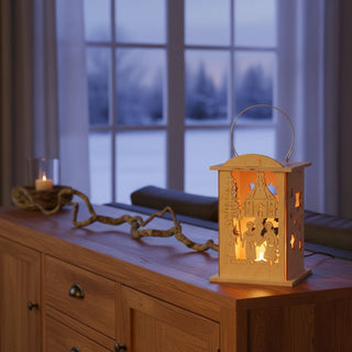 Laterne für 1 Teelicht oder mit LED‑Stripe „Seiffener Kirche“, 16 cm, aus naturbelassenem Holz mit filigraner Darstellung der Seiffener Kirche und zwei Kurrendesängern unter einem Stern, dekorativ auf einem Holzsideboard mit Zweigen arrangiert, vor einem großen Fenster mit verschneiter Winterlandschaft, warm beleuchtet durch ein Teelicht im Inneren.