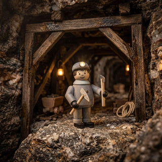 Miniatur „Bergmann mit Hammer und Hacke“ (ca. 5 cm) aus naturbelassenem Holz, mit einer kleinen Figur in Bergmannskleidung und Grubenlampe, die Hammer und Hacke in den Händen hält. Die Szene ist in einem detailreich gestalteten Bergwerksstollen mit Holzbalken, Loren, Gestein und warmer Beleuchtung dargestellt, was eine authentische und rustikale Atmosphäre erzeugt.
Geben Sie Ihr Feedback zu BizChat ab.