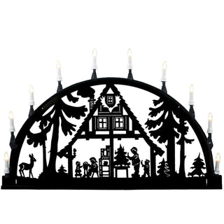 Der 10-flammige-Metalllichterbogen ist ideal für den Außenbereich. Sie können den Bogen im Garten, an die Garagenwand oder an die Hausmauer anbringen. Dieses Motiv zeigt eine gemütliche Weihnachtszeit im Wohnhaus, mit Kamin, Weihnachtsbaum und glücklichen Menschen umgeben vom dunklen und kalten Winterwald. Das Kerzenlicht des Bogens bringt Wärme und Gemütlichkeit. Bild 1.