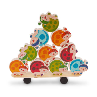 „Holzspielzeug in Form einer bunten Pyramide aus Marienkäfern. Die Marienkäfer sind in verschiedenen Farben – grün, blau, orange und rot – bemalt, haben Gesichter und schwarze Punkte auf den Flügeln. Das Spielzeug steht auf einer flachen Holzplatte mit zwei schwarzen Rädern darunter.“