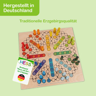 „Ein Brettspiel mit dem Namen ‚Raus mit Dir‘ für 8 Spieler. Das Spielbrett zeigt eine kreisförmige Anordnung von farbigen Spielfeldern in Rot, Orange, Gelb, Grün, Blau und Lila. Die Felder bestehen aus kleinen Kreisen, die durch Linien verbunden sind. In den farbigen Bereichen sind passende Spielfiguren aufgestellt. Oben links steht der Text ‚Hergestellt in Deutschland‘ und darunter ‚Traditionelle Erzgebirgsqualität‘. Unten links befindet sich ein Etikett mit der Aufschrift: ‚HESS Brettspiel „Raus mit Dir“ 