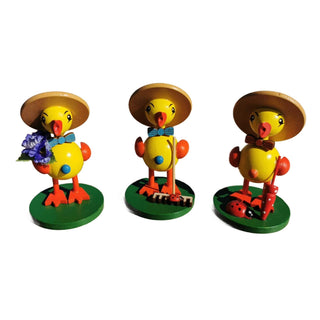 3 süße Osterküken in gelb mit Blume, Rechen und Schirm in der Hand. 