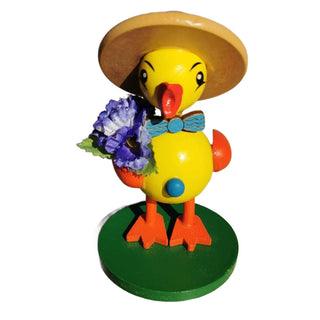 Gelbes Entenküken mit Hut und Blume in der Hand.