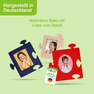 Das Bild zeigt drei Puzzleteile, die als Bilderrahmen gestaltet sind. Ein blaues Puzzleteil zeigt ein Kind im gelben Hemd, ein beiges Puzzleteil eine Person im weißen Hemd und ein rotes Puzzleteil ein Kind im gestreiften Hemd. Oben links steht auf grünem Hintergrund „Hergestellt in Deutschland“. In der Bildmitte steht „Natürliche Deko mit Liebe zum Detail“. Unten ist eine Verpackung mit der Aufschrift „Hess Messlatte 'Bilder-Puzzle' 3-teilig“ und dem Hess-Logo zu sehen.