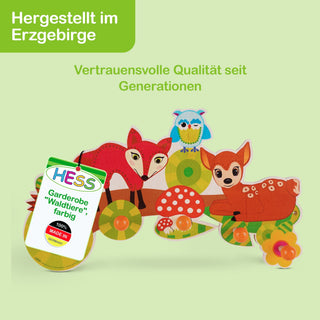 „Bunte Garderobe mit Waldtieren: Ein Fuchs, eine Eule und ein Reh sind abgebildet. Die Haken sind als Blumen und Pilze gestaltet. Links oben steht ‚Hergestellt im Erzgebirge – Vertrauensvolle Qualität seit Generationen‘. Ein Etikett trägt die Aufschrift ‚HESS Garderobe „Waldtiere“, farbig – 100% MADE IN GERMANY‘.“