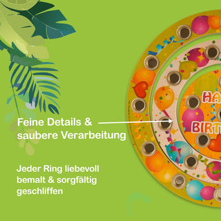 Bunter, runder Geburtstagsring aus Holz mit mehreren konzentrischen Ringen, die jeweils mehrere Löcher enthalten – vermutlich für Kerzen. Die Ringe sind mit Motiven wie Ballons und Konfetti verziert. Links im Bild steht der Text: „Feine Details & saubere Verarbeitung“ sowie „Jeder Ring liebevoll bemalt & sorgfältig geschliffen“.