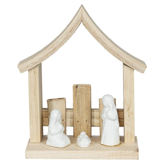 Krippenszene aus naturbelassenem Holz mit weißen Keramik-Figuren von Maria, Josef und dem Jesuskind. Maria kniet links, Josef steht rechts, das Jesuskind liegt in einer Krippe in der Mitte. Die Szene ist in einem schlichten Holzstall arrangiert.