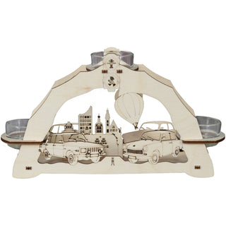 Dieser kleine hölzerne Lichterbogen in Natur kann mittels 3 Teelichter wunderbar Gemütlichkeit und Wärme vermitteln. Ideal für Retro-Begeisterte. Im Hintergrund sieht man Leipzig mit seinen schönsten Sehenswürdigkeiten. Ein Heißluftballon steigt gerade auf. Der Weg dahin war damals mit einem Trabant und einem Wartburg eine spannende Reise. Mittig im Bogen ist eine Ampelanlage mit Männchen eingearbeitet.