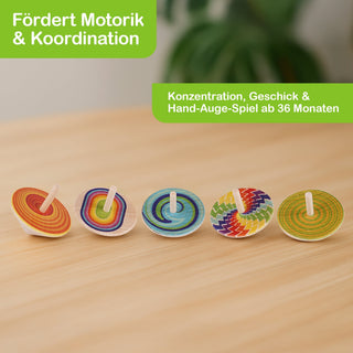  Fünf bunte Holzkreisel mit unterschiedlichen Mustern und Farbkombinationen stehen auf einer Holzoberfläche. Oben links im Bild befindet sich ein grünes Feld mit dem Text „Fördert Motorik & Koordination“, unten rechts daneben ein weiteres grünes Feld mit „Konzentration, Geschick & Hand-Auge-Spiel ab 36 Monaten“.