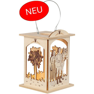Aus unserer neuen Kollektion. Die kleine rechteckige, naturfarbene und mit dezenten Schattierungen in Szene gesetzte Laterne zeigt das Märchen vom singenden, klingenden Bäumchen. Das Zauberbäumchen ist an 3 Seiten dargestellt. Das Prinzenpaar mit Pferd sieht man auf der 4. Seite. Mit einem Teelicht kann man die Holzlaterne romantisch zum strahlen bringen. Bild 1.