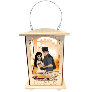 Eine Holzlaterne passend zum Märchenmotiv "DEFA-Schneewittchen®" mit Doppelfunktion, Teelicht oder Stripe ist hier zu sehen. Farbig abgesetzt wird Schneewittchen und der Prinz dargestellt. Beleuchtete Darstellung. Bild 2.