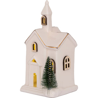 LED-beleuchtete Keramikkirche mit Holzfenstern, 15 cm hoch, batteriebetrieben, mit kleinem künstlichem Weihnachtsbaum vor dem Gebäude.