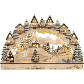 Beleuchtete Holzdekoration mit winterlichem Dorfmotiv, Häusern, Figuren beim Skifahren und Rodeln, verschneiten Bäumen und verziertem Sockel.