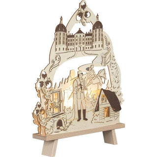 Hier ist die elektrische Standleuchte aus Holz seitlich abgebildet. Das bekannte Wintermärchen vom Aschenbrödel wird hier durch die Schattierungen detailgetreu dargestellt. Der Prinz mit dem Schuh, die Prinzessin zu Pferd, das prunkvolle Schloss Moritzburg, die Tauben, Rosalie die Eule und die drei Haselnüsse lassen den Märchenzauber unter Beleuchtung wirken. Bild 2.