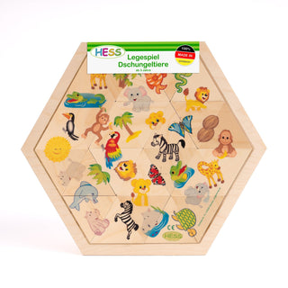 Ein sechseckiges Holzpuzzle mit bunten Dschungeltieren, darunter Krokodil, Affe, Elefant, Löwe, Papagei, Zebra, Giraffe und Schildkröte. Oben steht „Hess Legespiel Dschungeltiere ab 3 Jahren“ und „100% Made in Germany“. Das Puzzle ist farbenfroh und für Kinder ab drei Jahren geeignet.