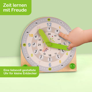 Kindgerechte Lernuhr mit bunten Zahlen und zwei grünen Zeigern, die von einer Kinderhand bewegt werden. Der Hintergrund ist hellgrün. Oben links steht „Zeit lernen mit Freude“, unten links „Eine liebevoll gestaltete Uhr für kleine Entdecker“.