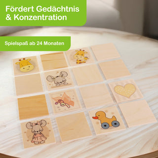 Ein Memo-Spiel mit dem Titel „Giraffe und Maus“ liegt auf einem Tisch. Es besteht aus 16 quadratischen Karten, von denen einige Illustrationen wie Giraffe, Maus, Herz und Ente zeigen, andere sind leer. Oben links steht „Fördert Gedächtnis & Konzentration“, darunter „Spielspaß ab 24 Monaten“.