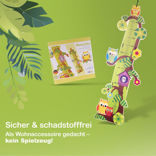 Bunte Messlatte für Kinder in Form eines Baumes mit gezeichneten Eulen und anderen Tieren. Im Hintergrund ist eine Verpackung mit derselben Messlatte zu sehen. Text im Bild: „Messlatte“ und „Sicher & schadstofffrei – Als Wohnaccessoire gedacht, kein Spielzeug!“
