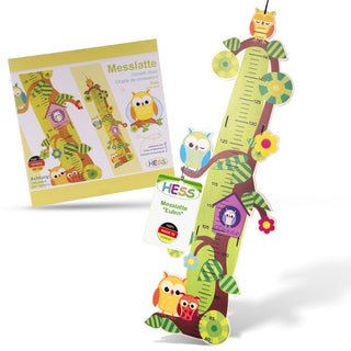 Bunte Messlatte für Kinder in Form eines Baumes, verziert mit Eulen und Blumen. Die Skala reicht von 70 cm bis 150 cm. Auf der Verpackung stehen die Begriffe „Messlatte“, „Growth chart“ und „Charte de croissance“. Ein Etikett trägt die Aufschrift „HESS Messlatte 'Eulen'“ sowie „Made in Germany“.
