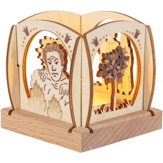 Der kleine Holz-Teelichthalter aus ist quadratisch und mit abgerundeten Enden und verschiedenen Blenden versehen. Zu sehen ist der böse Zwerg mit Feuerballen und das Zauberbäumchen. Hier ist der Teelichthalter beleuchtet dargestellt. Bild 3.