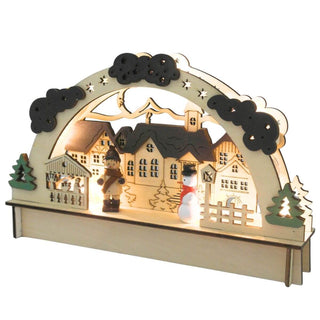 Beleuchteter LED-Holz-Lichterbogen mit einem liebevoll gestalteten Dorfmotiv: Mehrere Häuser mit detaillierten Fenstern und Dächern sowie eine Kirche mit Turm stehen im Zentrum. Links und rechts rahmen zwei Bäume die Szene ein. Im Vordergrund befinden sich eine Holzfigur in Winterkleidung und ein Schneemann mit rotem Schal und schwarzem Hut. Ein Bogen mit Sternen und Wolken überspannt das gesamte Arrangement. Schräge Ansicht