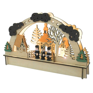 Beleuchteter LED-Holz-Lichterbogen mit einem kleinen Dorfmotiv: Im Zentrum steht eine Kirche mit orangefarbenem Dach und Turm, flankiert von zwei Häusern mit braunen Dächern. Davor stehen drei Kurrendefiguren. Die Szene ist von einem Bogen mit Wolken, Sternen und Bäumen eingerahmt. Schräge Ansicht