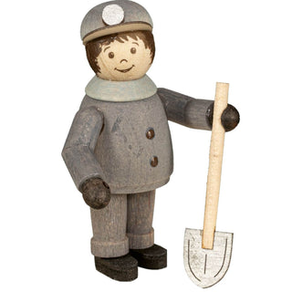 Die Abbildung zeigt eine Miniatur eines Bergmanns in grauer Uniform und Helm mit Grubenlampe, die eine Schaufel hält. Die Figur hat bemalte Gesichtszüge mit einem Lächeln.