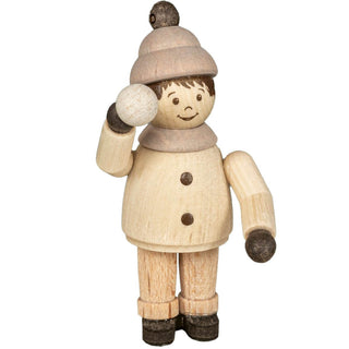 "Eine Holzfigur zeigt eine Person in Winterkleidung. Die Figur trägt eine Mütze mit einer Bommel, einen Schal und hat Knöpfe auf der Vorderseite des Mantels. Die Figur hält einen Schneeball in einer Hand und hat den anderen Arm ausgestreckt. Die Gesichtszüge sind einfach, mit Augen, Augenbrauen und einem lächelnden Mund."