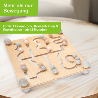 Holzspielzeug mit vier labyrinthartigen Bahnen, in denen bunte Kugeln bewegt werden können. Das Spielzeug steht auf einem hellen Holztisch. Oben links im Bild befinden sich zwei grüne Textfelder mit den Aufschriften: ‚Mehr als nur Bewegung‘ und ‚Fördert Feinmotorik, Konzentration & Koordination – ab 12 Monaten‘.