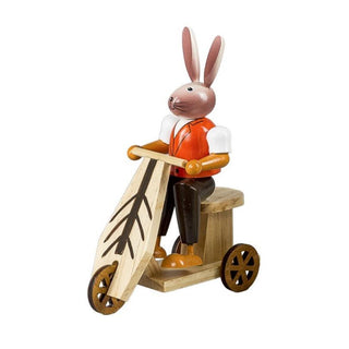 Farbiger Osterhase aus Holz auf einem Roller