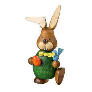Grün gekleideter Osterhase aus Holz mit einem Osterei und einem Vogel in der Hand
