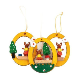 Gelbfarbene Ostereier aus Holz, zum Hängen, mit farbigen Osterhasen in der Mitte